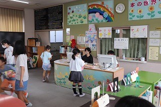 図書委員会の児童がカウンターで貸し出し等の手続きをします。