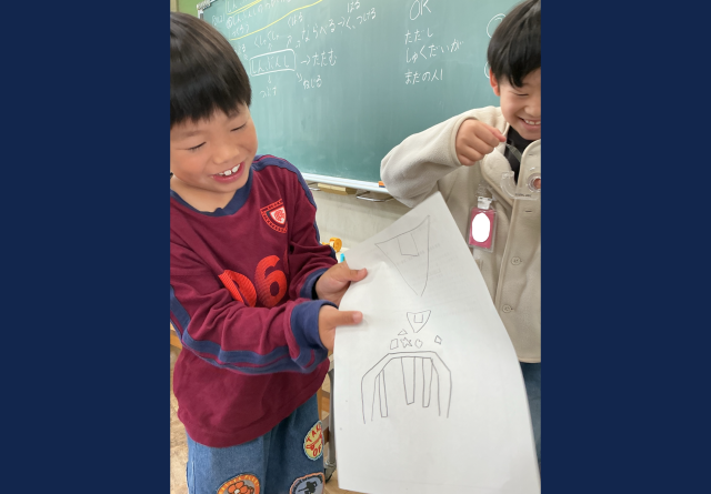 テントを作るための設計図を見せている子どもたち